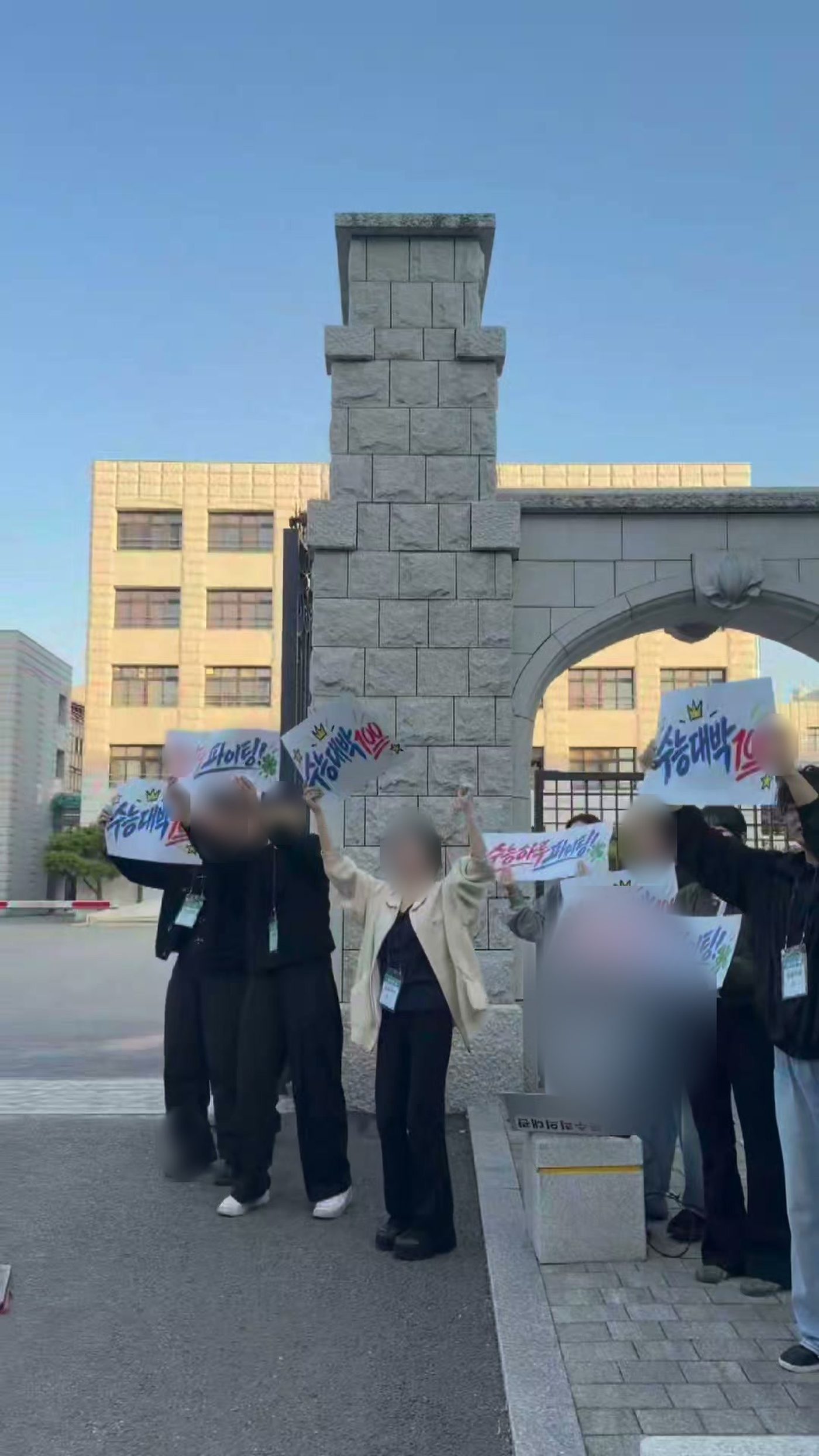 휘문중학교 정문에서 팔을 들어 수험생을 응원하는 수능하루 운영진